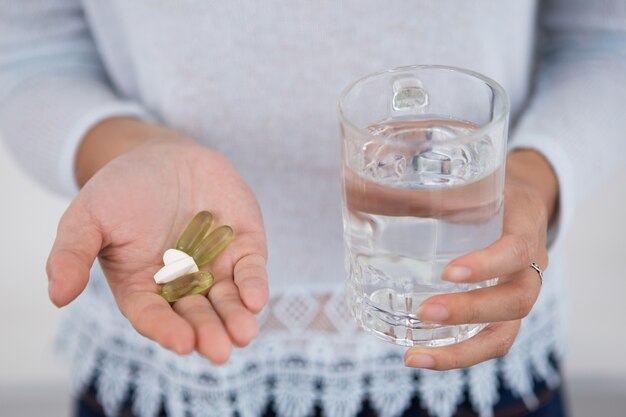 Freigegebene Ansicht des Mädchens mit Pillen und Glas Wasser