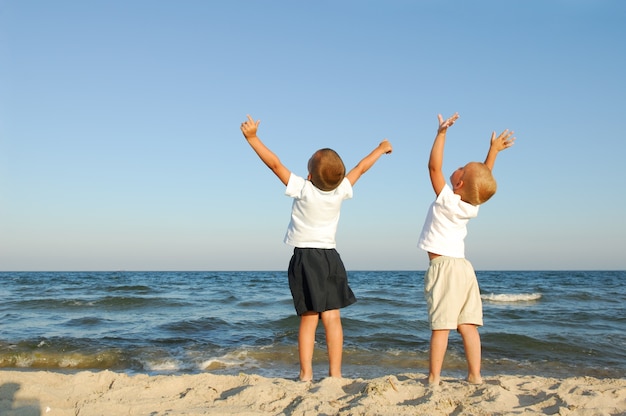 Freiheit. Zwei Jungen am Strand mit erhobenen Armen