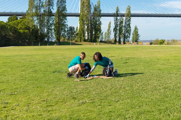 Freiwillige, die Abfall vom Gras aufheben