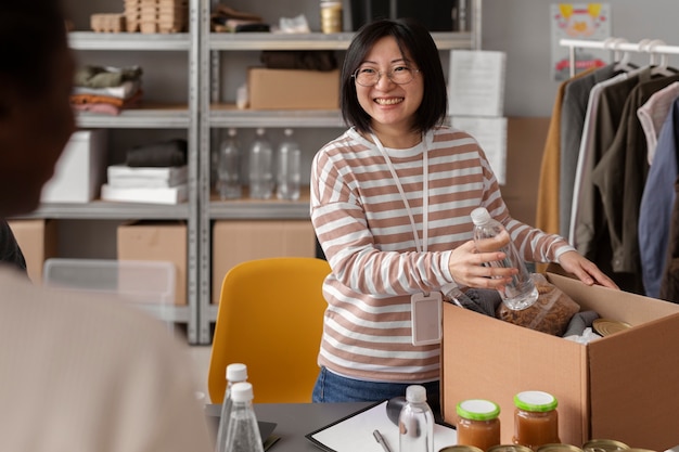 Freiwillige, die Lebensmittelspenden für wohltätige Zwecke in eine Kiste packen