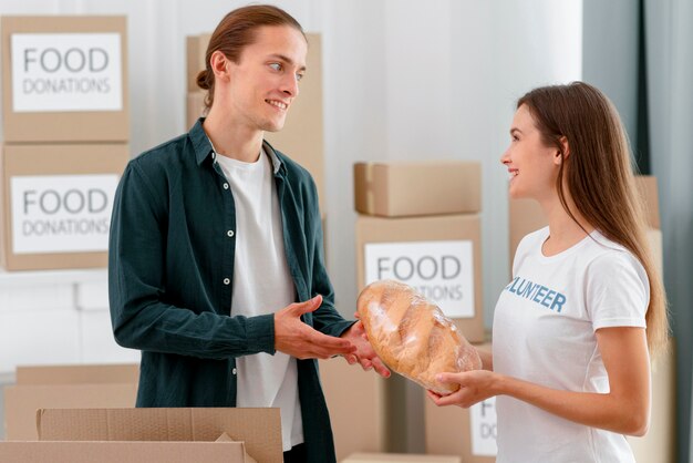 Freiwillige für Lebensmittelspende, die Brot an bedürftige Personen verteilt