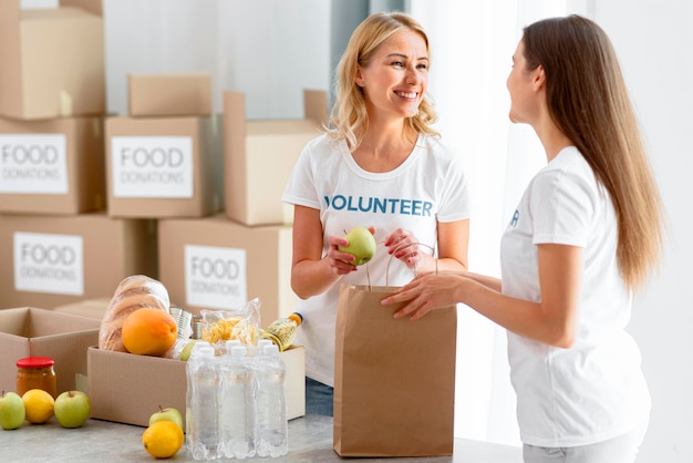 Freiwillige Helferinnen von Smiley packen Lebensmittel in Säcke und bereiten sie für die Spende vor