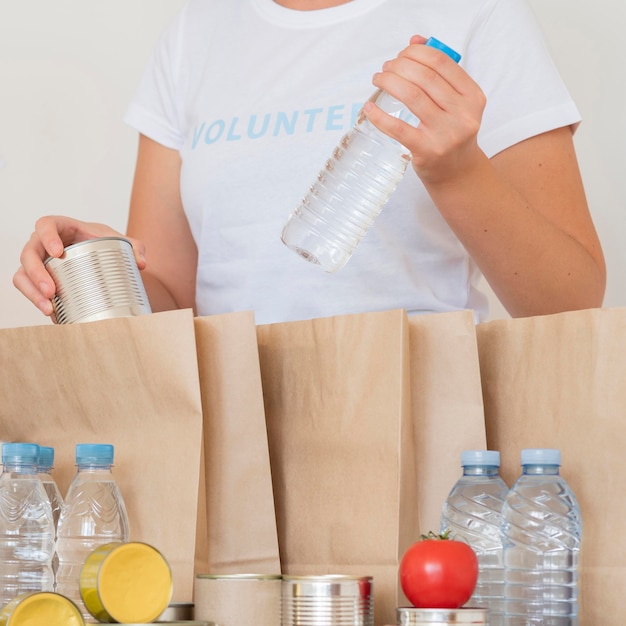 Kostenloses Foto freiwilliger, der wasserflasche für spende in tasche packt