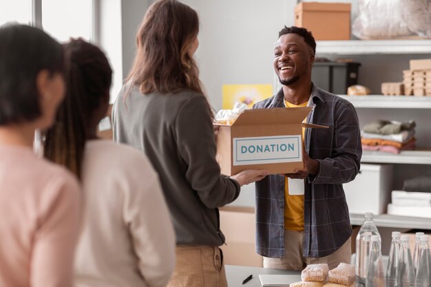 Freiwilliger sammelt eine Spendenbox von einem anderen Freiwilligen