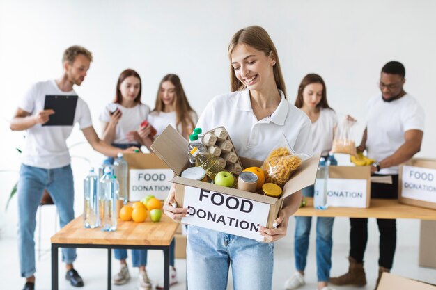 Freiwilliger Smiley, der Nahrungsmittelspenden im Kasten hält