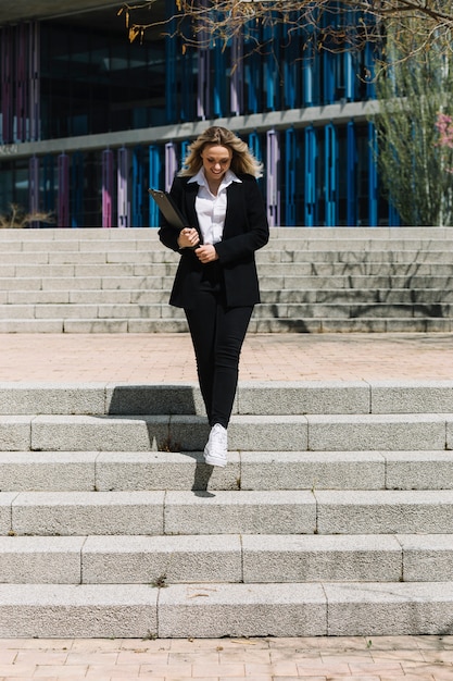 Freudig geschäftsfrau gehen die Treppe hinunter in die Stadt