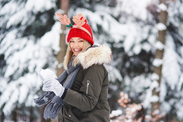 Freudige Frau, die Spaß mit Schnee hat