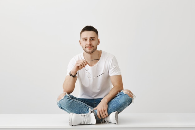 Freudiger junger Mann mit Brille posiert