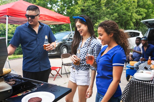 Freund grillt Burger auf einer Heckklappenparty