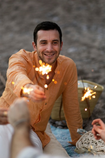 Kostenloses Foto freunde am strand mit wunderkerzen