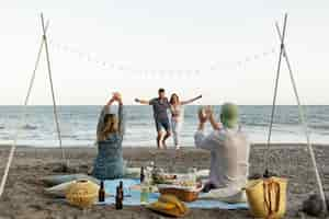 Kostenloses Foto freunde am strand tanzen während der party zusammen