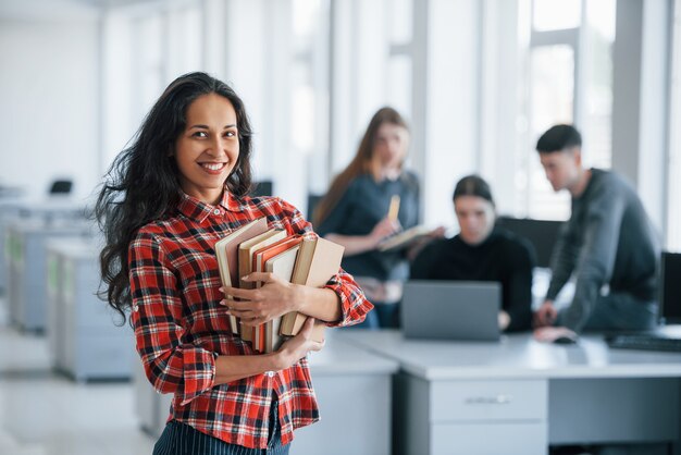 Freunde dahinter. Gruppe junger Leute in Freizeitkleidung, die im modernen Büro arbeiten