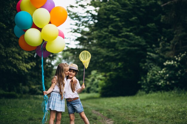 Freunde der kleinen Mädchen mit Ballonen im Wald