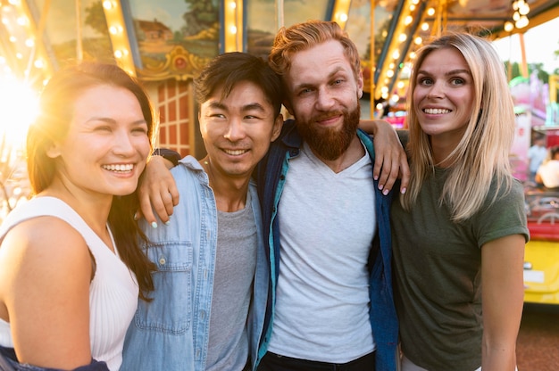 Kostenloses Foto freunde der vorderansicht, die am jahrmarkt aufwerfen