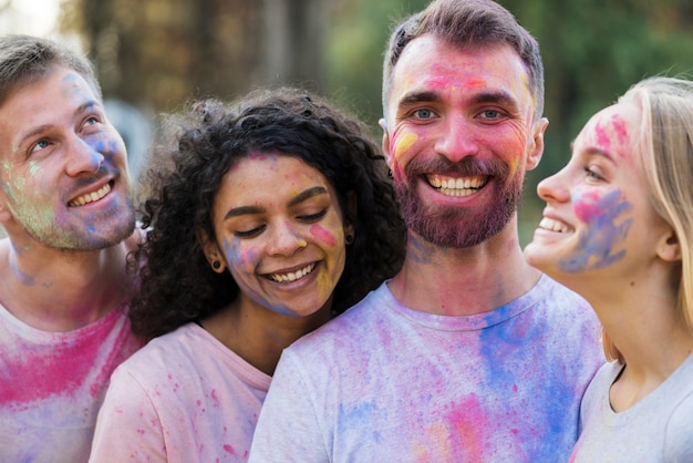 Freunde, die bedeckt in der pulverisierten Farbe lächeln und aufwerfen