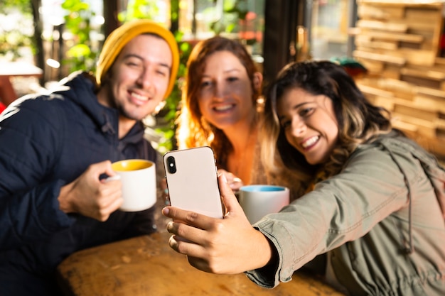 Freunde, die ein selfie an der Kaffeestube nehmen