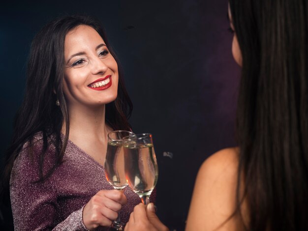 Freunde, die einander mit Champagner an der Party der neuen Jahre betrachten