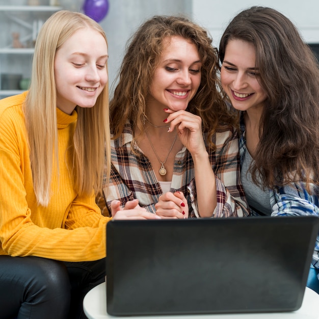 Kostenloses Foto freunde, die einen laptop verwenden