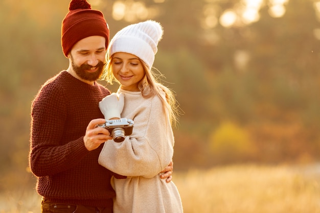 Kostenloses Foto freunde, die fotos auf kamera mit kopienraum betrachten