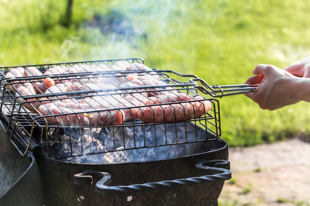 Freunde, die grillen und in der Natur zu Mittag essen.