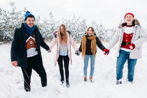 Freunde, die Hände im Winterwald anhalten