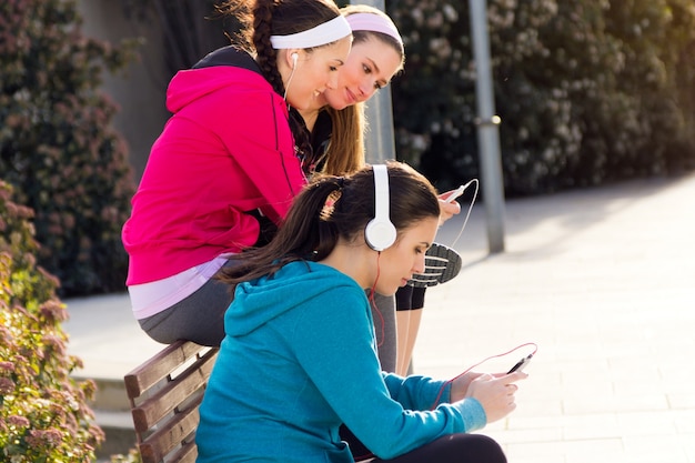 Freunde, die nach dem Training Spaß mit Smartphones haben