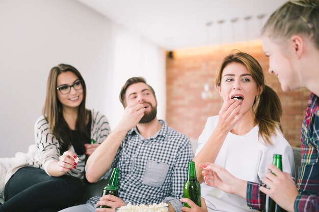 Freunde, die Popcorn teilen und Bier trinken