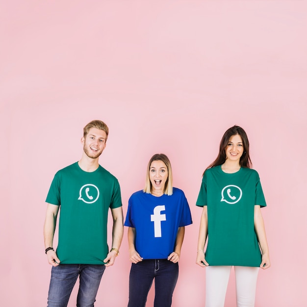 Freunde, die Social Media-Ikonent-shirt auf rosa Hintergrund tragen