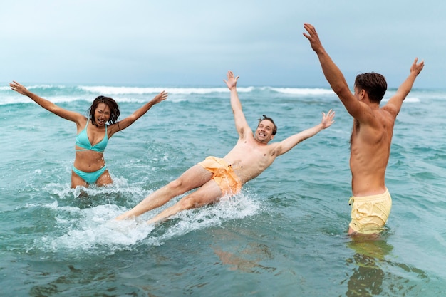 Freunde, die Spaß am Meer haben, mittlerer Schuss