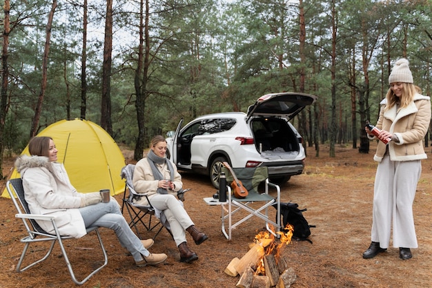 Freunde, die während des Camps am Lagerfeuer sitzen