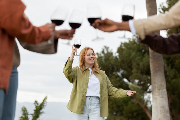 Freunde, die während einer Party im Freien mit Gläsern Wein anstoßen