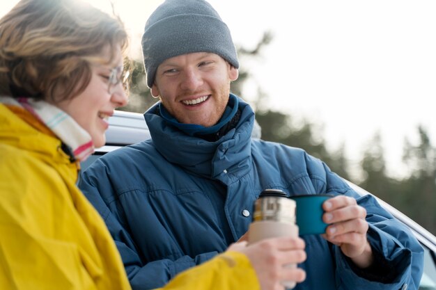 Freunde, die während einer Winterreise ein heißes Getränk genießen