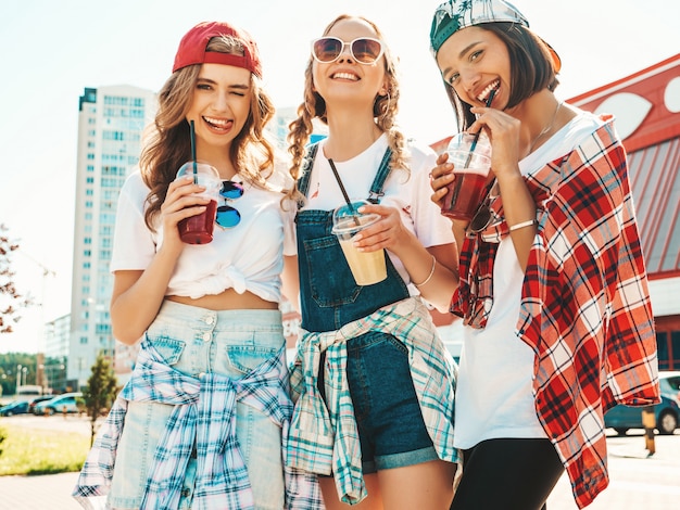 Freunde halten und trinken frisches Cocktail-Smoothie-Getränk im Plastikbecher mit Strohhalm