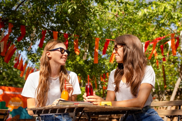 Freunde im Park halten frische Saftflaschen