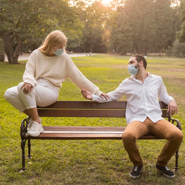 Freunde im Park üben soziale Distanz