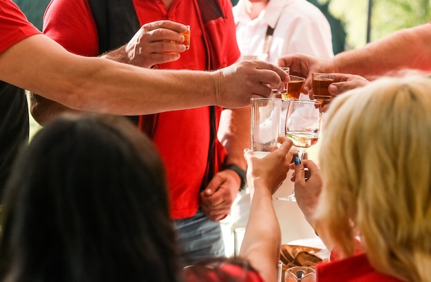 Freunde in roten Kleidern hoben ihre Gläser im Urlaub zusammen