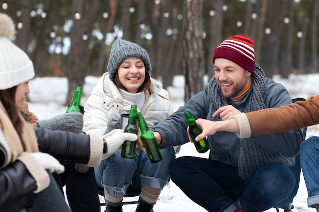 Kostenloses Foto freunde klirren mit bierflaschen in der natur