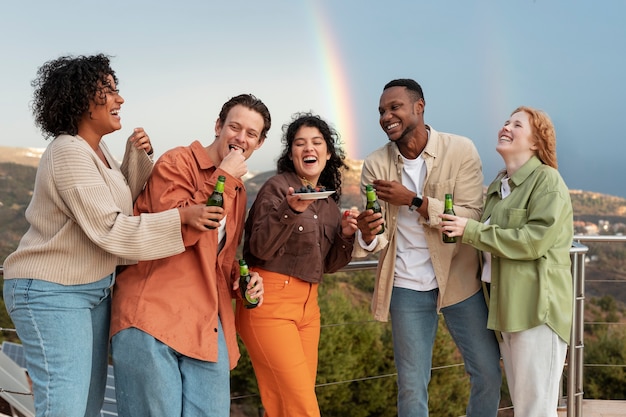Freunde lachen und trinken Bier während der Party im Freien