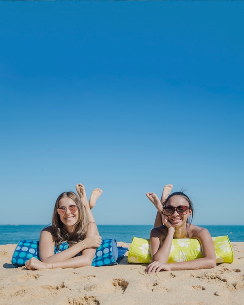 Kostenloses Foto freunde liegen am strand zusammen