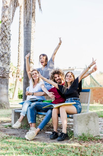 Freunde mit Büchern, die an der Bank zujubeln