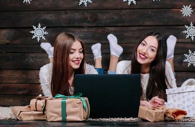 Freunde mit einem Laptop und Weihnachtsgeschenke