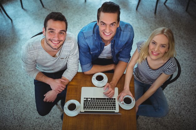 Freunde mit Laptop, während Kaffee in CafÃ ©