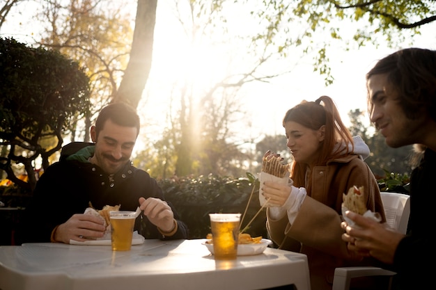 Freunde mittleren Alters, die sich beim Picknick gemeinsam amüsieren