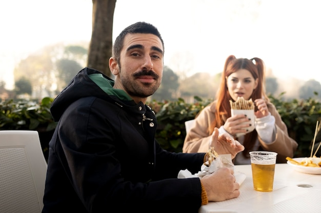 Freunde mittleren Alters, die sich beim Picknick gemeinsam amüsieren