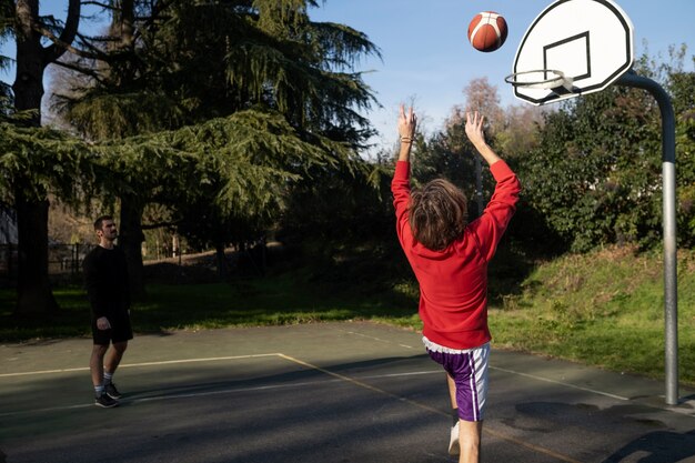 Freunde mittleren Alters, die zusammen Spaß beim Basketballspielen haben