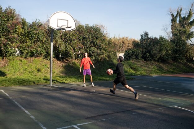 Freunde mittleren Alters, die zusammen Spaß beim Basketballspielen haben