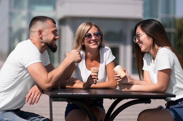 Freunde plaudern, während sie an einem Tisch sitzen