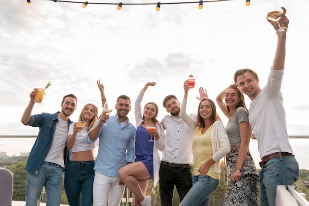 Freunde posieren mit Getränken auf einer Party