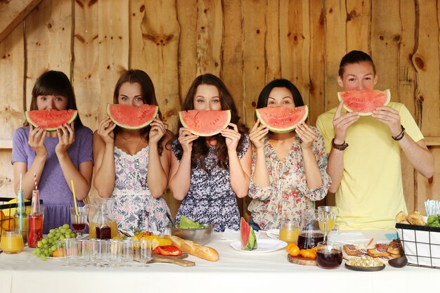 Freunde posieren mit Wassermelonenscheiben