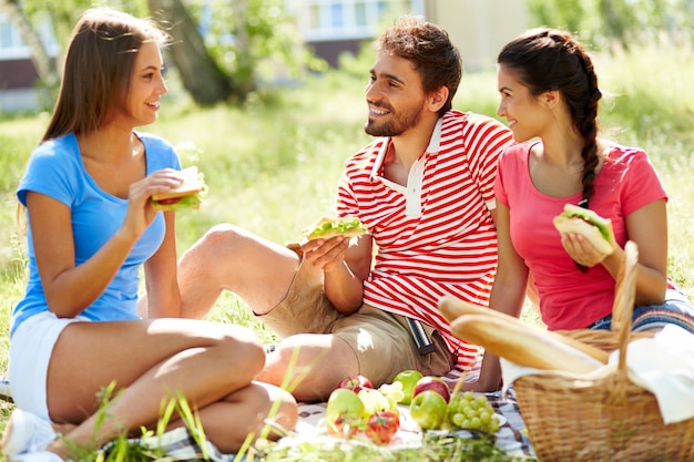 Freunde reden und essen im Park